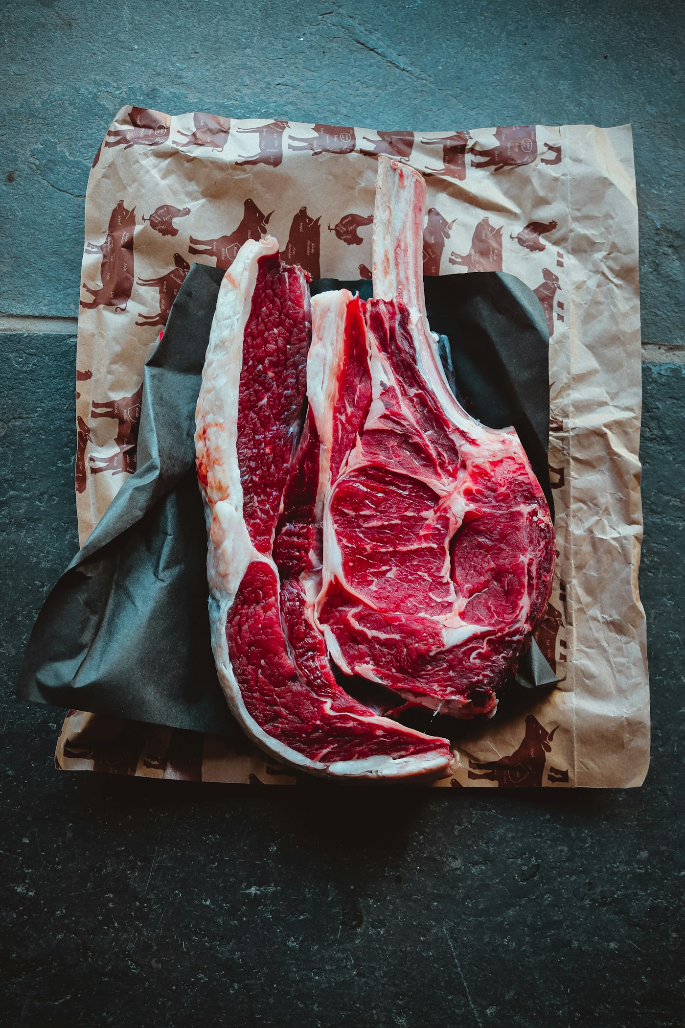 A dark red cut of raw meat on butcher paper