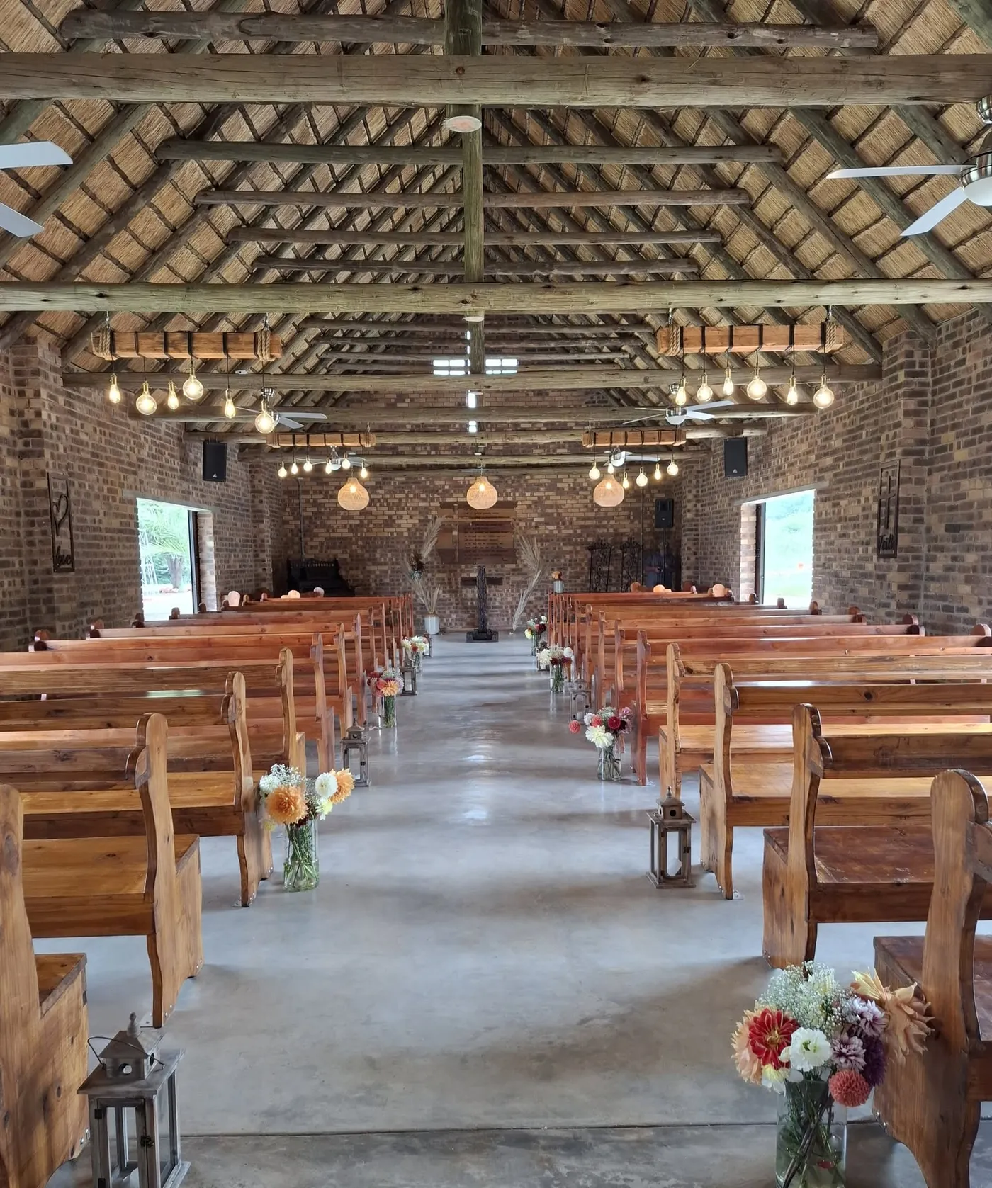 The Maroela chapel with wooden pews, thatched roof and hanging bulbs