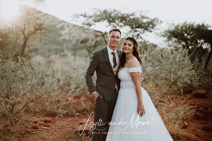 A couple walking among bushveld trees