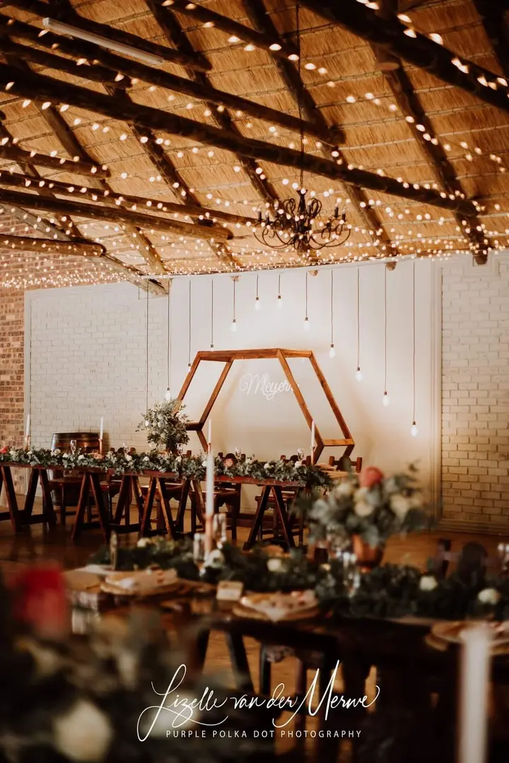 The reception hall set with a wooden arch and candles