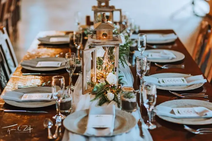 A wedding table with lanterns and greenery