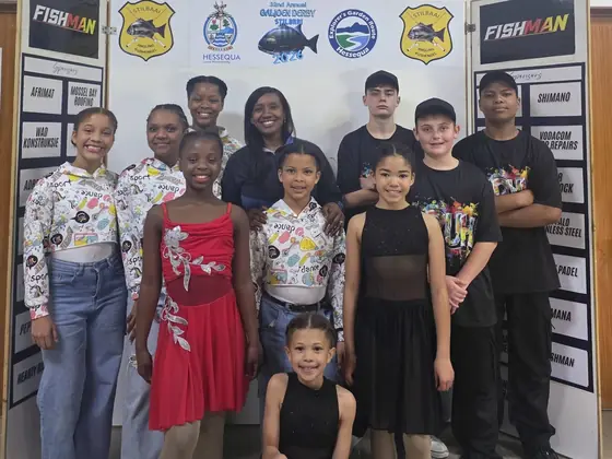 Studio E dancers in performance outfits grouped together after a show.