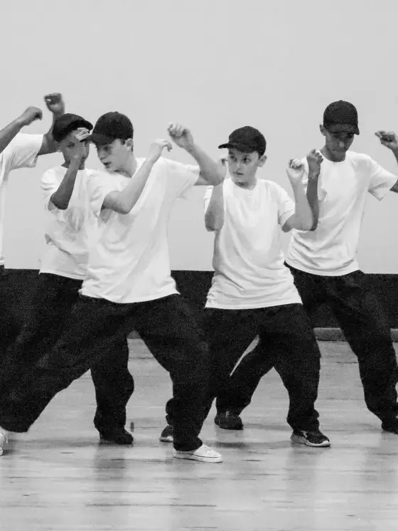 Black and white photo of the boys' crew in white t-shirts mid routine.